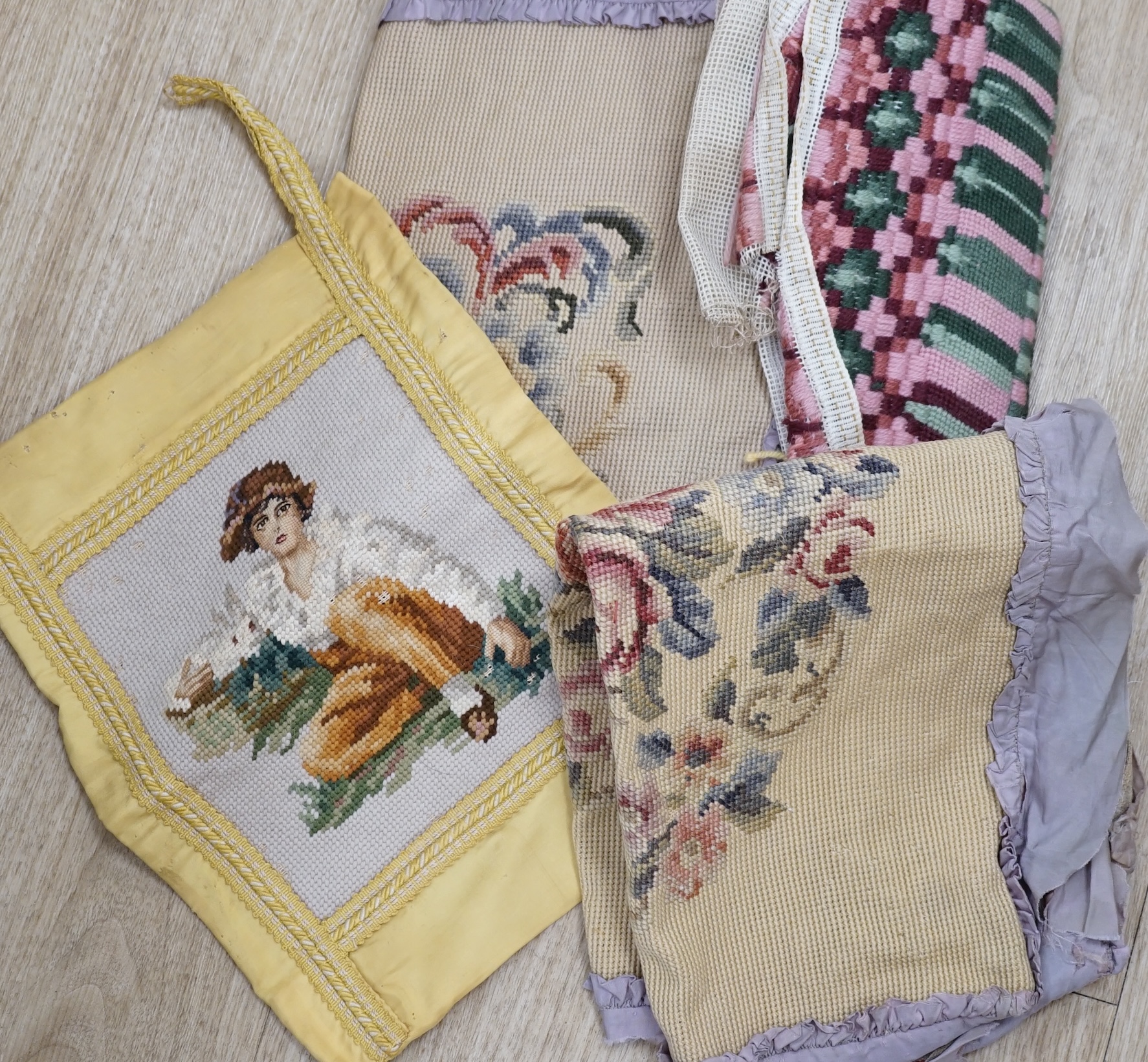 A collection of tie backs and needlepoint cushion covers and panels and two horse's head wall hooks